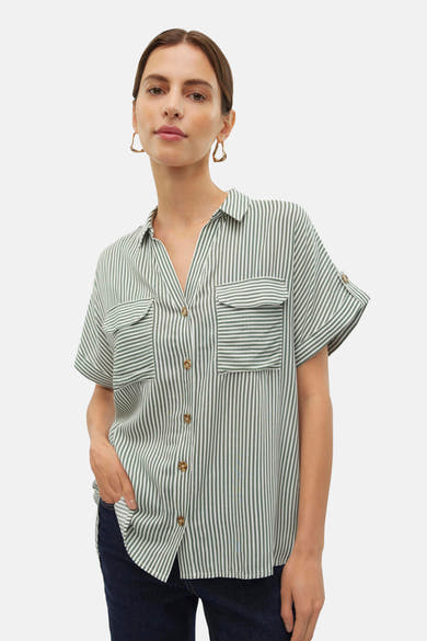 Chemise à manches courtes verte de VERO MODA® à rayures verticales, poches plaquées, manches retroussées, portée avec un jean foncé.