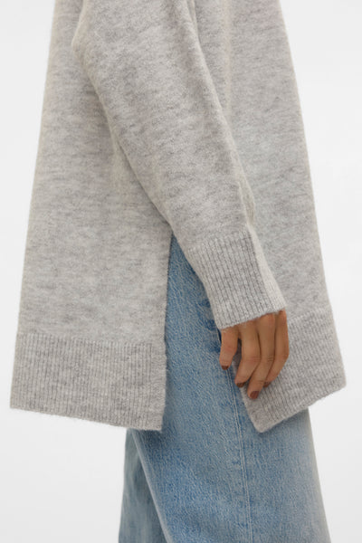 Pull à col en V gris de VERO MODA, porté avec un jean en denim bleu, en vue de côté.
