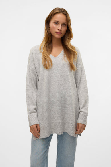 Pull à col en V gris de Vero Moda, porté avec un jean décontracté.
