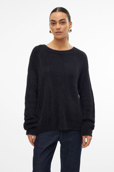 Zwarte trui met ronde hals van VERO MODA, gedragen met een wijde jeans en leren enkellaarsjes.