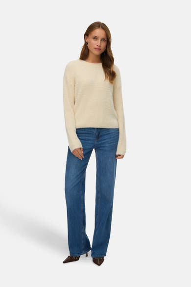 Rode rondehals-trui van VERO MODA, gedragen met een high-waist spijkerbroek en bruine stiletto's.