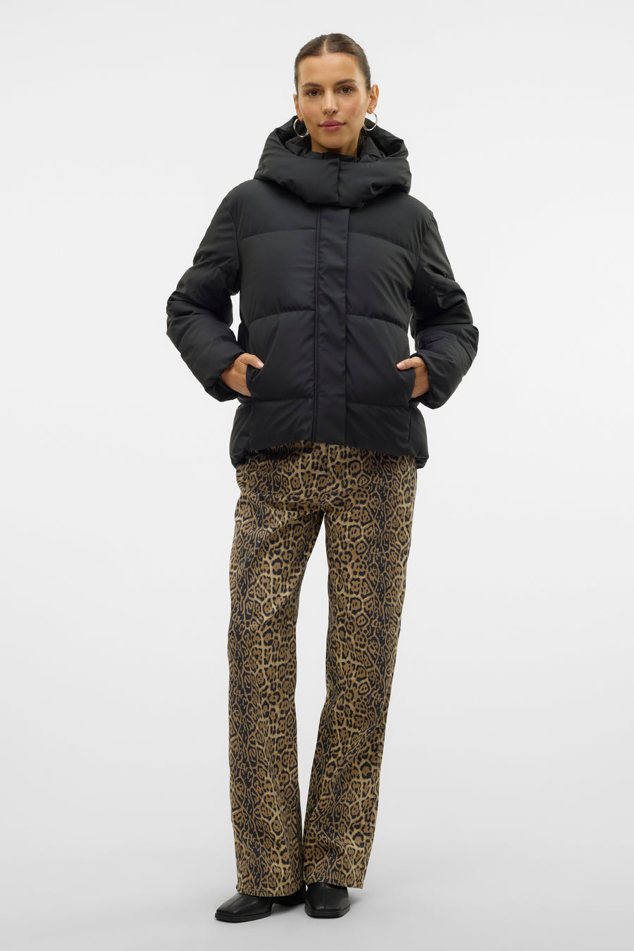 Veste courte noire de VERO MODA, portée avec un pantalon à motif léopard et des chaussures noires.
