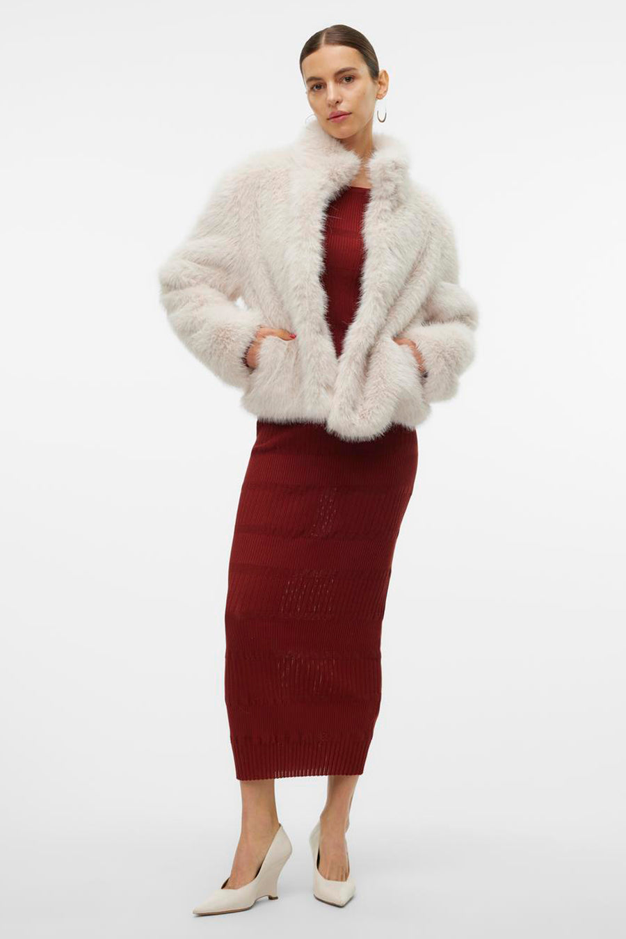 Veste courte écru de Vero Moda, portée sur une robe moulante bordeaux, avec des escarpins ivoire.