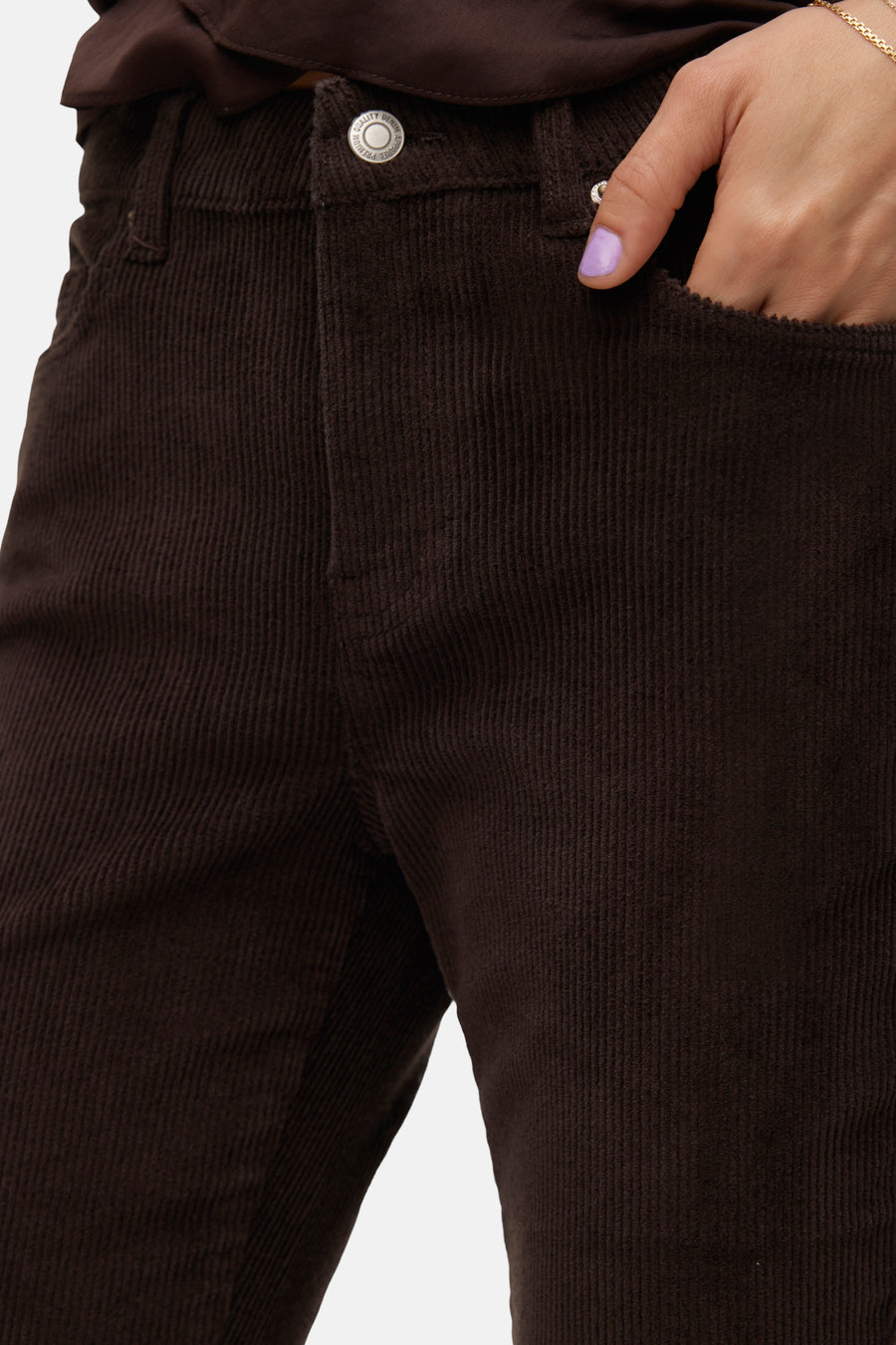 Pantalon marron en velours côtelé de VERO MODA, avec une main dans la poche.