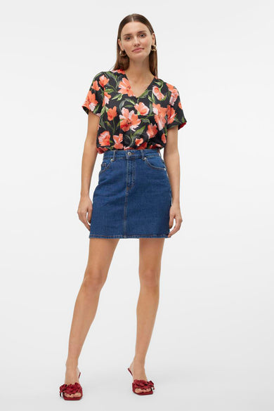 T-shirt à manches courtes multicolore de VERO MODA® avec motif floral et porté avec une jupe en jean.