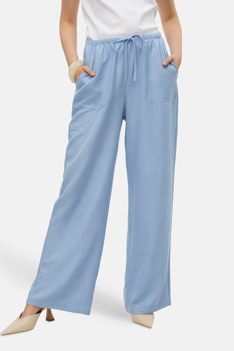 Pantalon bleu clair par VERO MODA®, coupe ample, avec cordon de serrage et poches plaquées.
