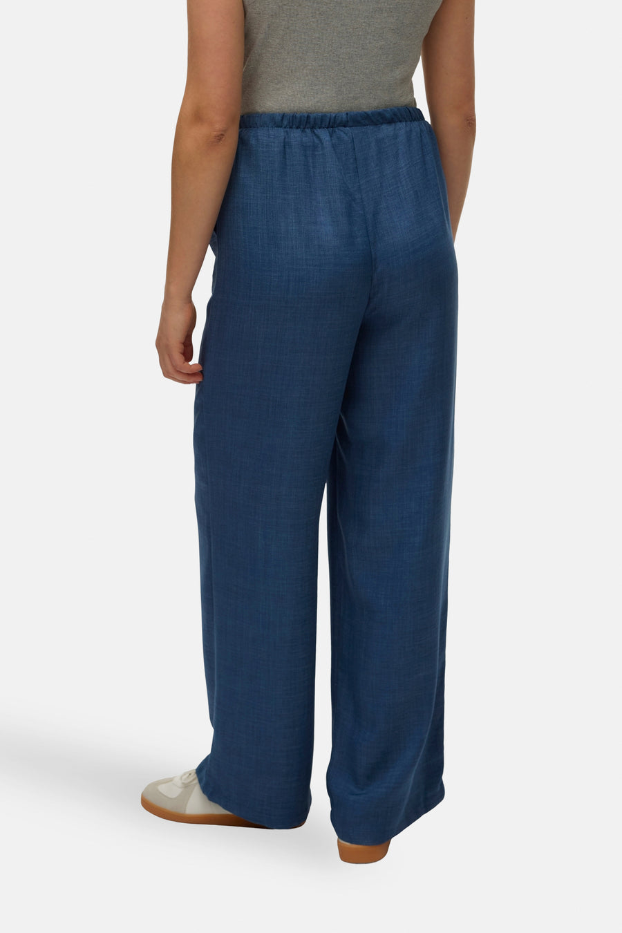 Pantalon coloré bleu par VERO MODA, ample et fluide, avec ceinture élastique, porté avec un t-shirt gris.