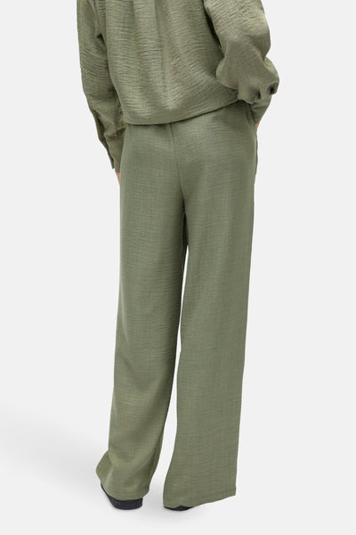 Pantalon coloré vert de VERO MODA, coupe ample, texture légèrement froissée.
