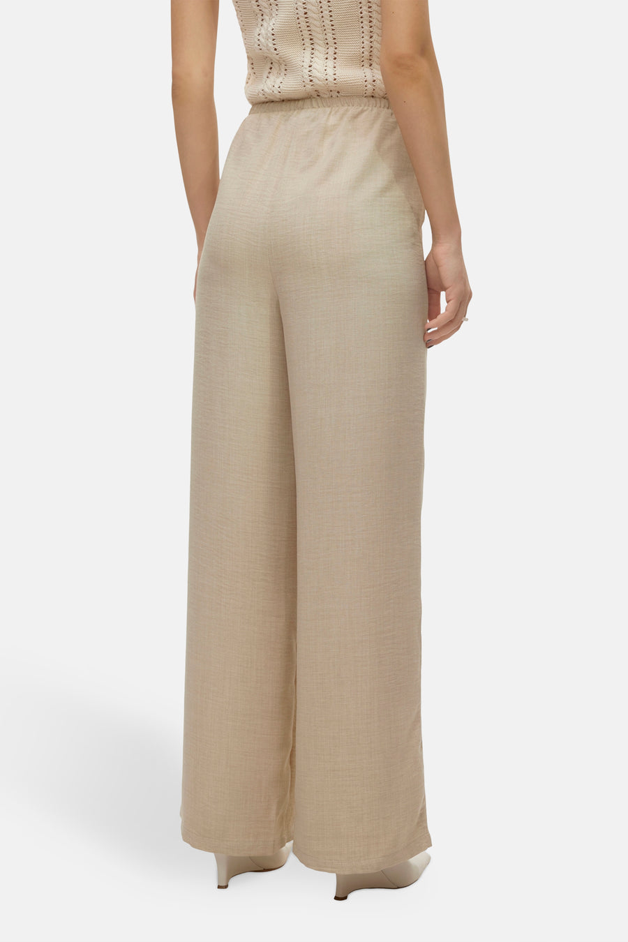 Pantalon coloré beige de VERO MODA, coupe ample et taille élastique, porté avec un haut assorti.
