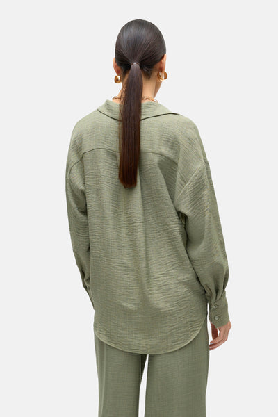 Chemise à manches longues verte de VERO MODA, coupe ample, portée avec un pantalon assorti, vue de dos.