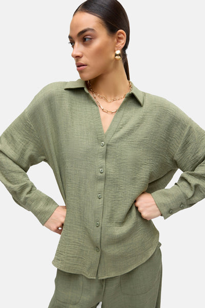 Chemise à manches longues verte de VERO MODA, avec boutons et collier doré.