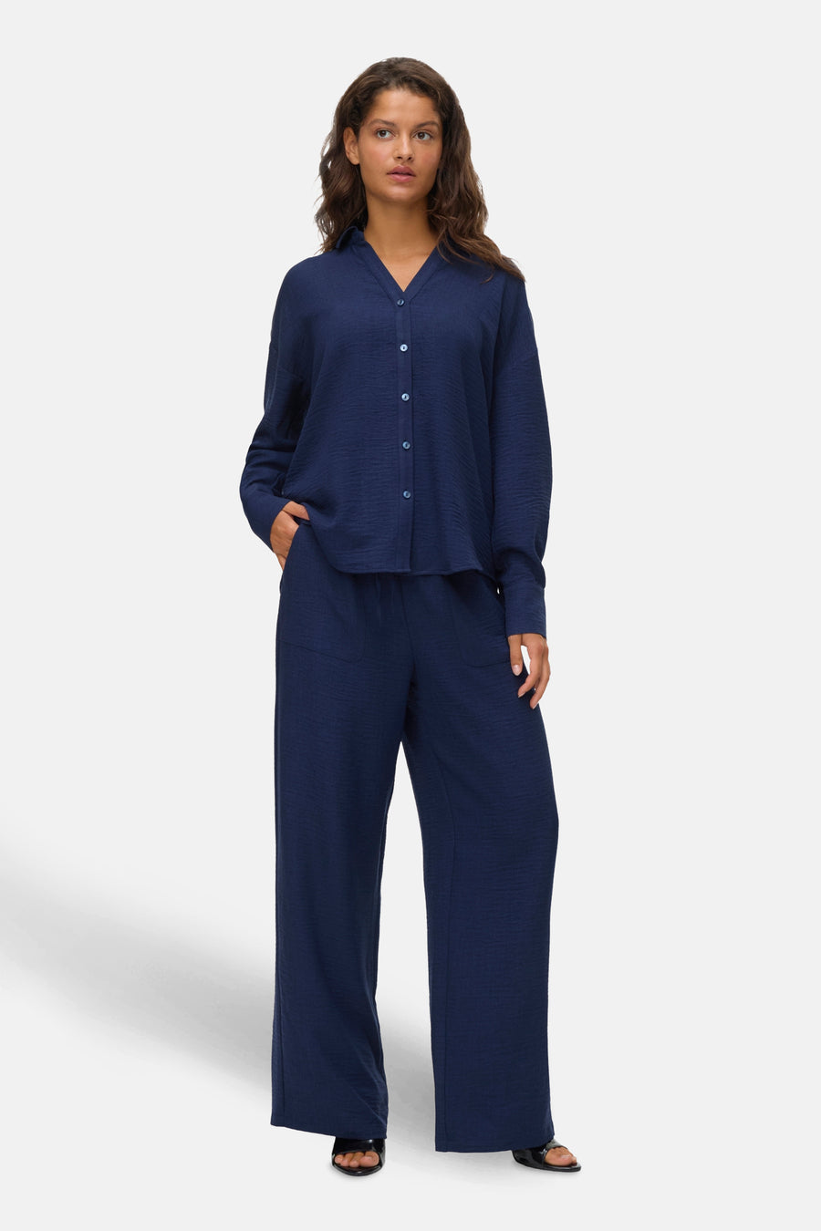 Chemise à manches longues bleue de VERO MODA, avec une texture subtile et portée avec un pantalon assorti.