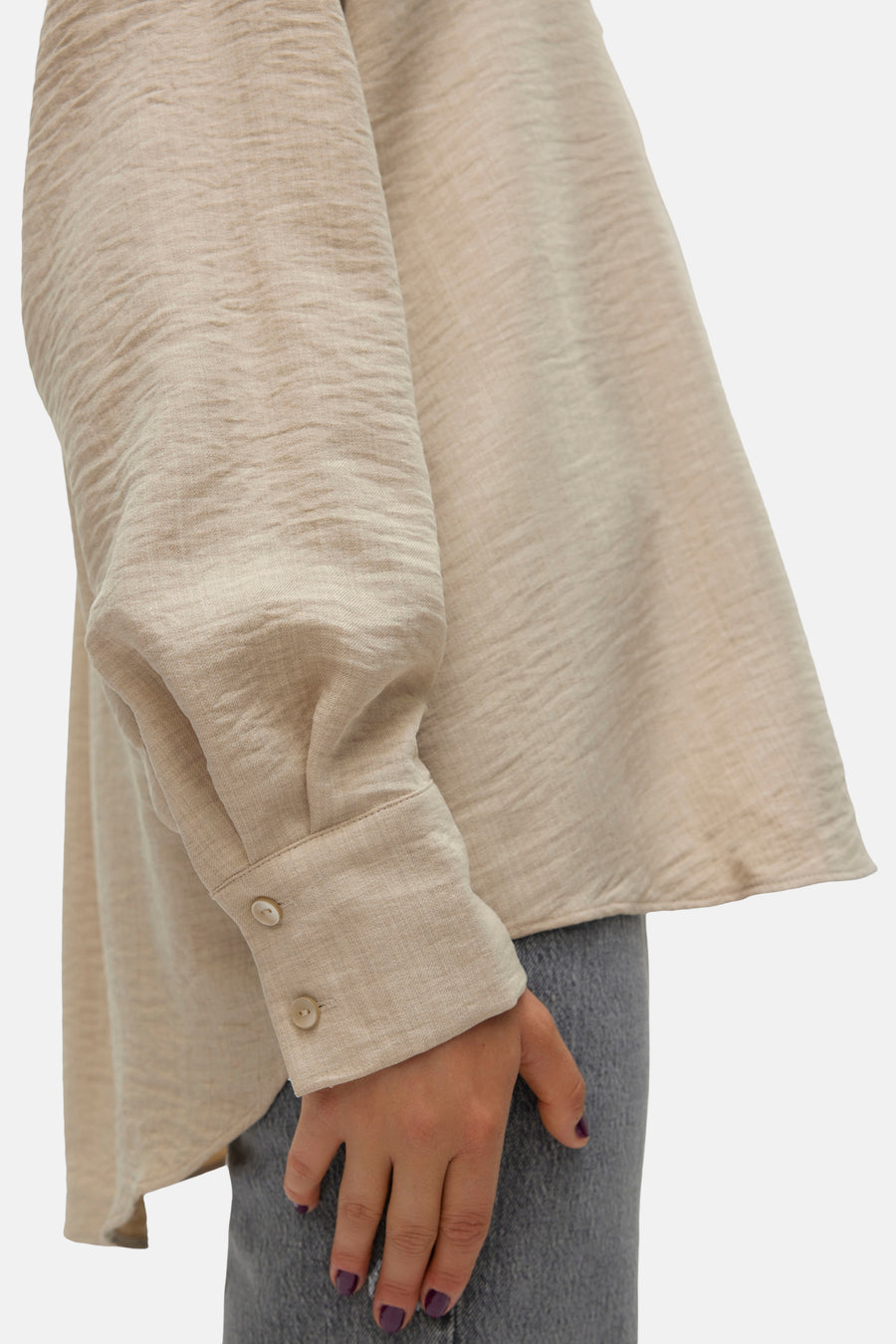Chemisier beige à manches longues de VERO MODA, avec une texture froissée et des boutons aux poignets.