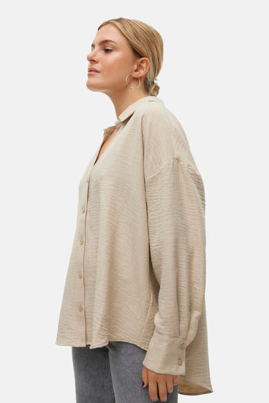 Chemisier beige à manches longues de VERO MODA, avec une texture subtile et des boutons apparents.