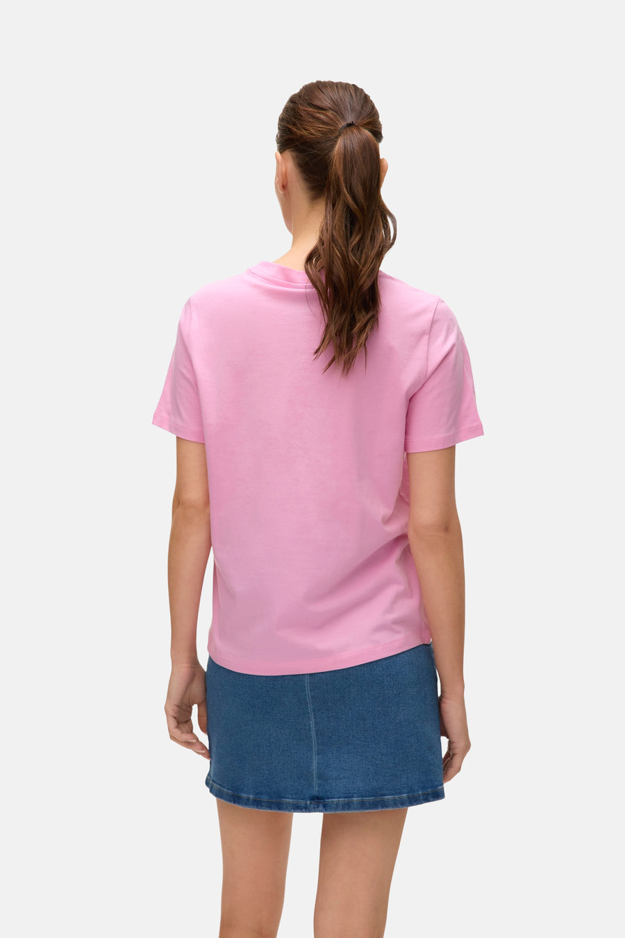 T-shirt rose à manches courtes de VERO MODA, porté avec une jupe en jean bleu, vue de dos.
