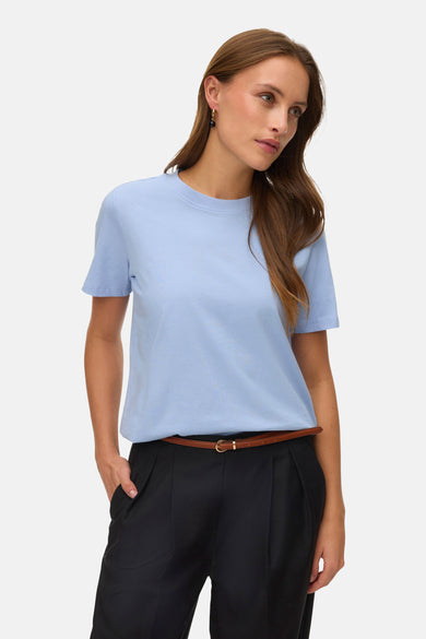 T-shirt bleu à manches courtes de VERO MODA, porté avec un pantalon noir et une ceinture marron fine.