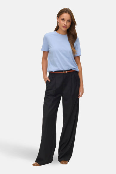 T-shirt à manches courtes bleu de VERO MODA®, porté avec pantalon noir taille haute et ceinture marron.