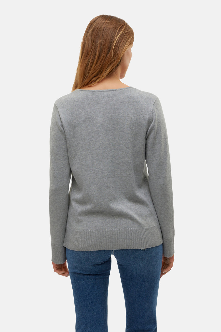 Pull gris à col en V de VERO MODA®, vu de dos, porté avec un jean bleu.
