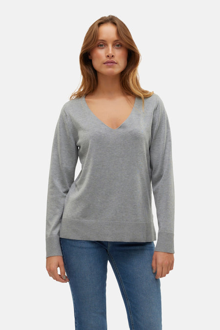 Grijze V-hals trui van VERO MODA, gedragen met een blauwe jeans.