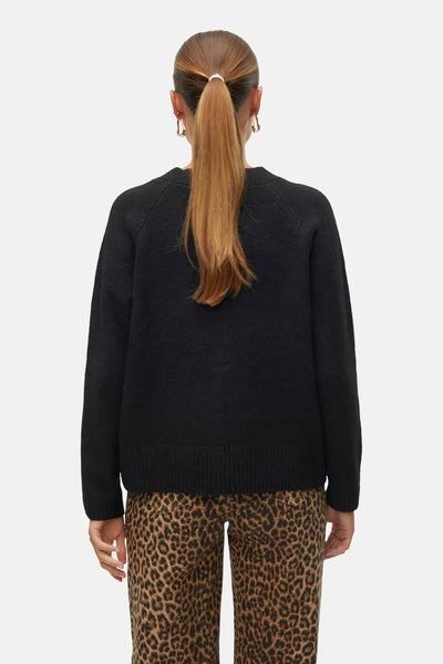 Cardigan noir par VERO MODA® porté avec un pantalon à motif léopard, vue de dos.
