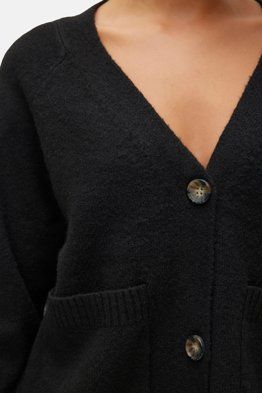 Zwarte VERO MODA cardigan met V-hals en zichtbare knopen, met opgestikte zakken.