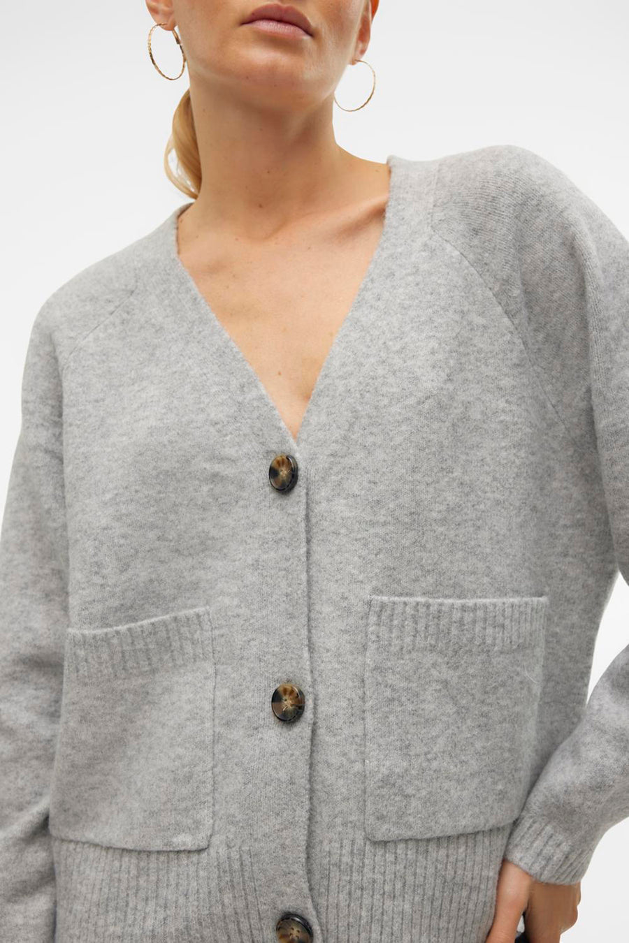 Cardigan gris de VERO MODA, avec fermeture boutonnée, poches plaquées et manches longues.