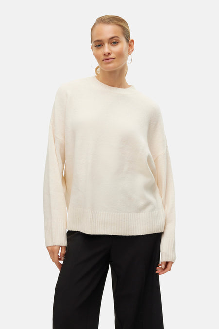 Ecru ronde hals trui van Vero Moda, gedragen met een wijde zwarte broek en oorringen.