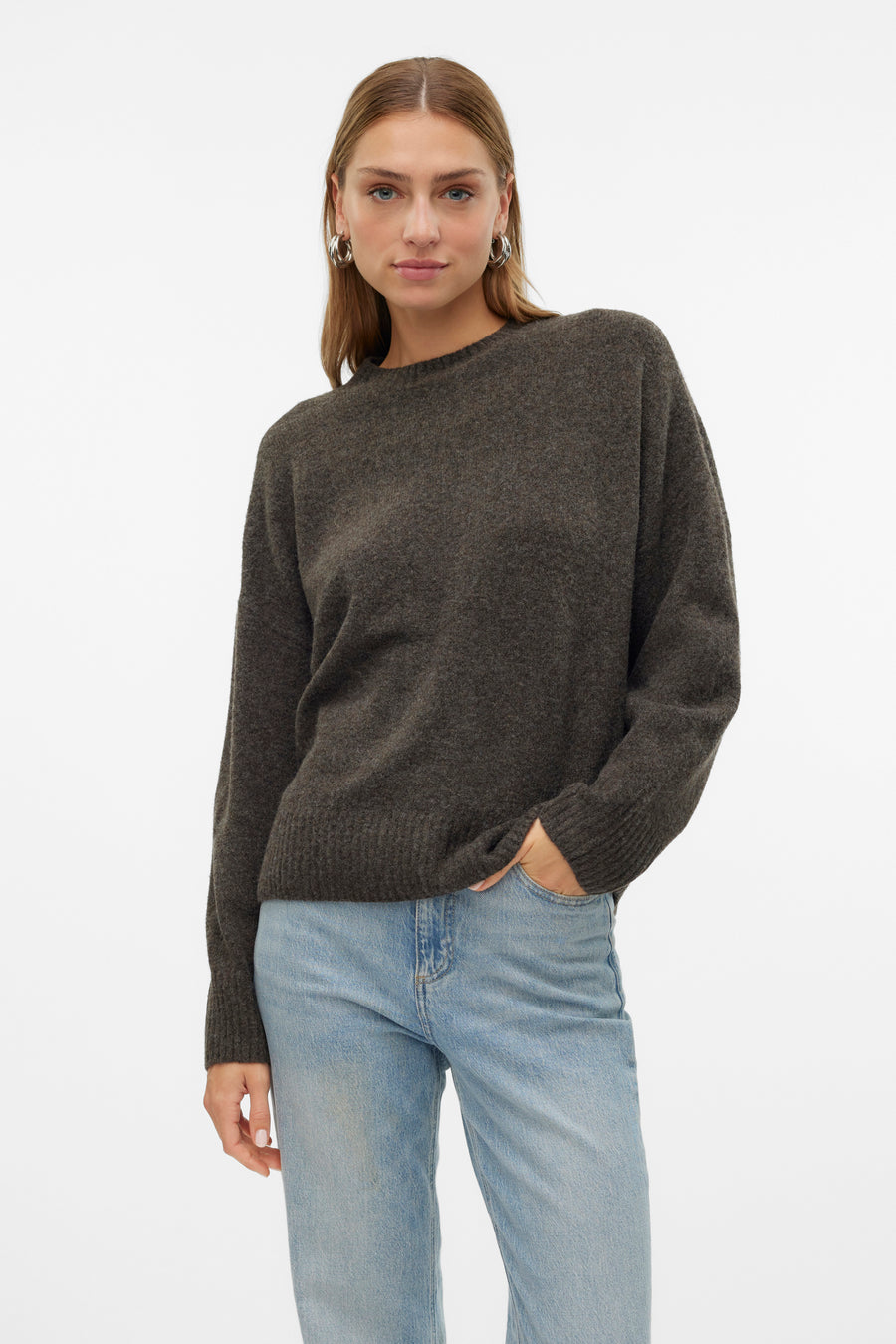 Pull à col rond marron de VERO MODA, porté avec un jean bleu clair, avec des boucles d'oreilles argentées.
