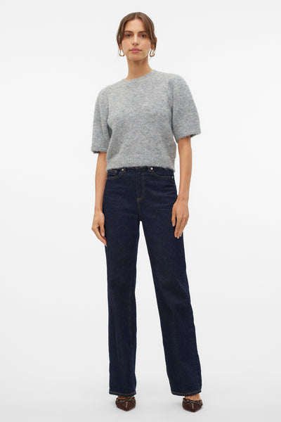 Pull à col rond gris par VERO MODA, avec des manches courtes et porté avec un jean taille haute.