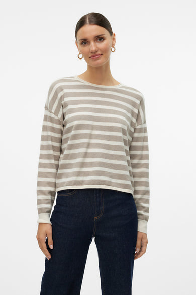 Pull col rond rayé beige et blanc de Vero Moda, porté avec un jean bleu foncé.

