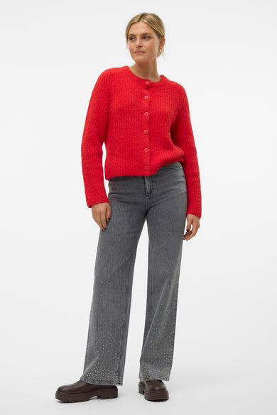 Gilet rouge de VERO MODA, porté sur un jean gris à strass, avec des bottines marron.

