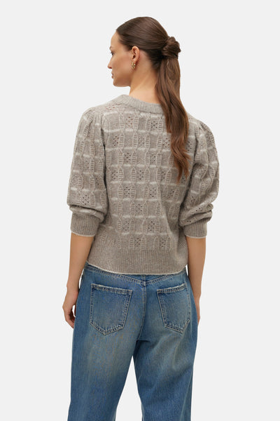 Beige ronde hals trui van VERO MODA, met ajourpatroon, pofmouwen en gedragen met een spijkerbroek.