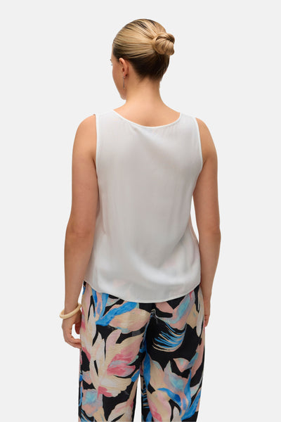 Wit overhemd met lange mouwen van VERO MODA® gedragen met een broek met bloemenpatroon, achtergezicht.