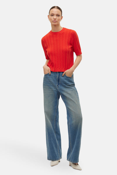 Rode trui met ronde hals van Vero Moda, met een getextureerd visgraatpatroon, gedragen met een wijde jeans.