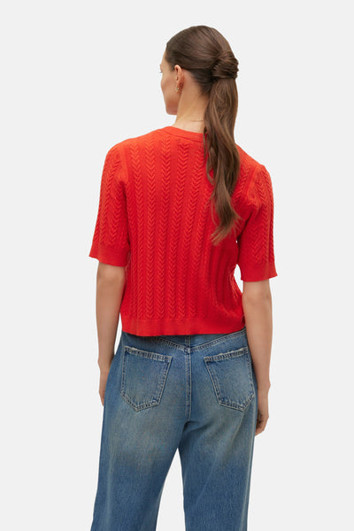 Rode ronde hals trui van VERO MODA, in kabelsteek, gedragen met een high-waisted jeans.