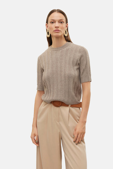 Ronde mouw kleding van Vero Moda, met een verticale torsademotief, gedragen met een beige broek en een bruine riem.