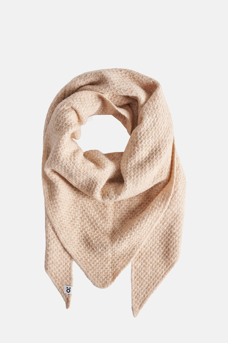 Beige sjaal van OPUS in kabelsteek, zachte en pluizige textuur, in meerdere lagen gevouwen.