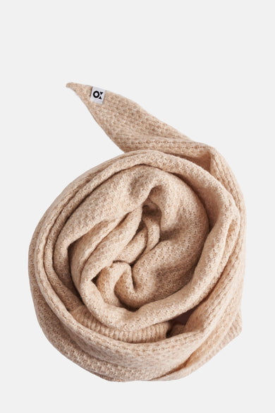 Écharpe beige d'OPUS, enroulée, avec une étiquette de marque visible.