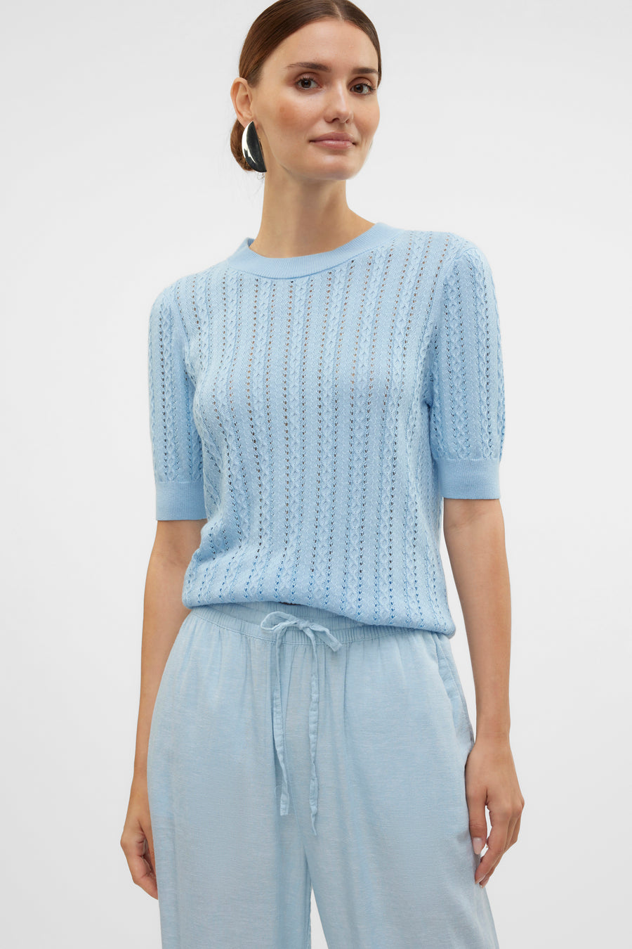 Blauwe trui met ronde hals van VERO MODA, in opengebreide stof, gedragen met een bijpassende broek.