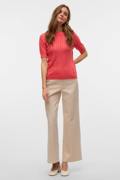 Coral ronde hals trui van VERO MODA®, open gebreid patroon, gedragen met een beige broek met hoge taille.