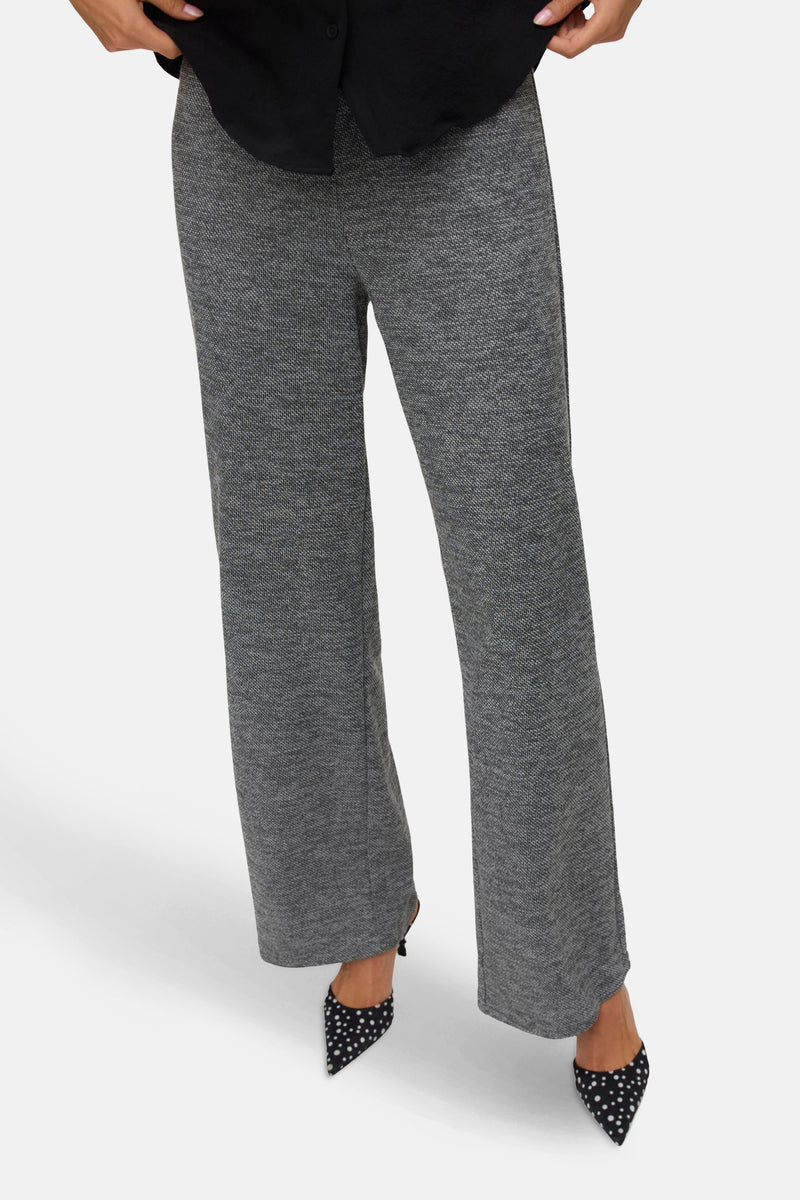 Grijze gemêleerde broek van Vero Moda, rechte pasvorm, gedragen met zwart-witte gestipte pumps.