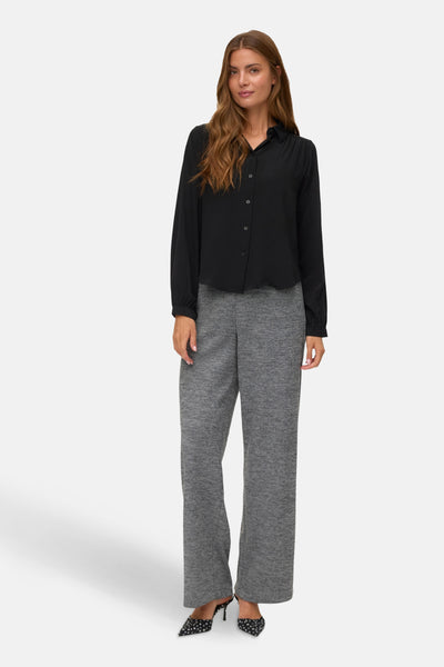 Grijze broek van VERO MODA, rechte en losse pasvorm, gedragen met een zwart overhemd met knopen en stippenpumps.