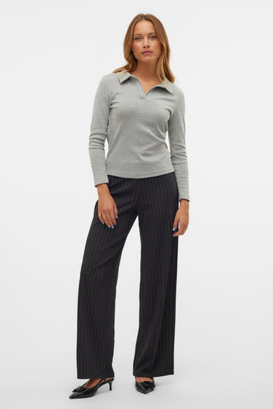 Pantalon noir à rayures by Vero Moda, porté avec un haut gris à manches longues et des chaussures noires à talons.