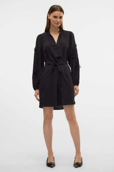 Zwarte jurk van Vero Moda, met lange mouwen versierd met borduursels en bijpassende riem.