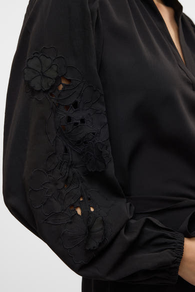 Zwarte jurk van VERO MODA met lange mouwen geborduurd met bloemenpatronen.