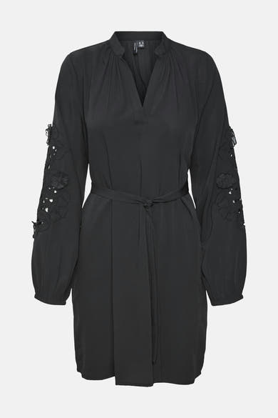Zwarte jurk van VERO MODA met lange mouwen versierd met uitgesneden bloemen en bijpassende riem.