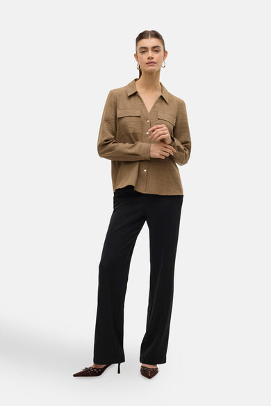 Bruine blouse met lange mouwen van VERO MODA, gedragen met een zwarte broek en bruine schoenen.