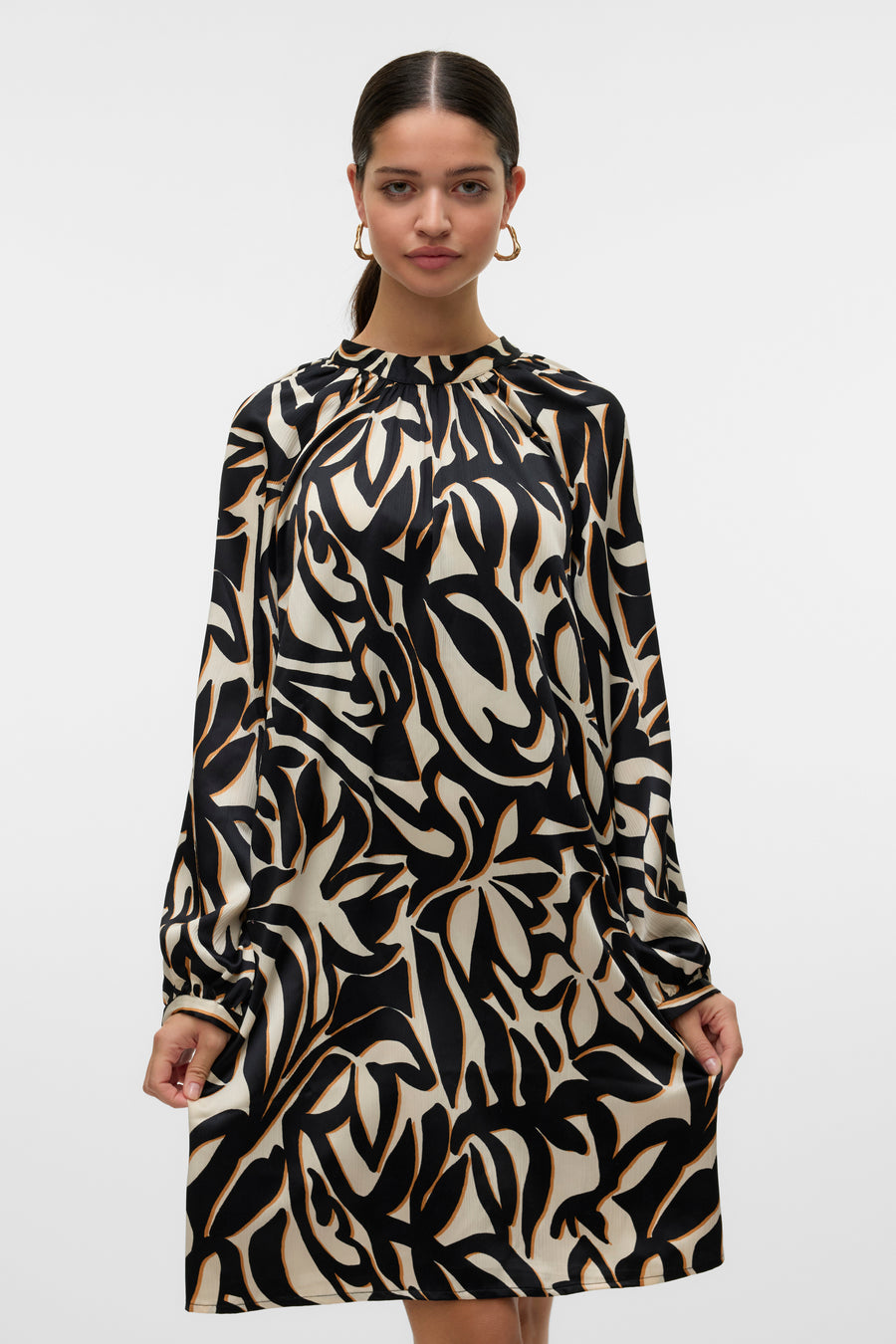 Robe multicolore de Vero Moda, à motif abstrait noir et beige, avec des manches longues.
