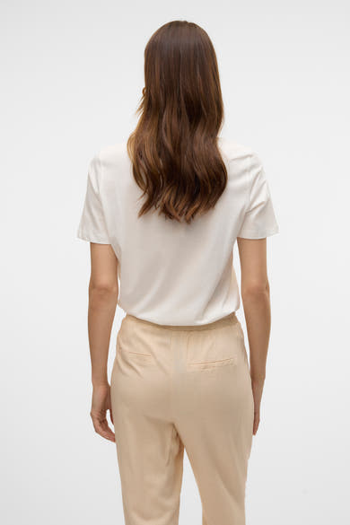 Wit T-shirt met korte mouwen van VERO MODA, gedragen met een beige broek, achtergezicht.