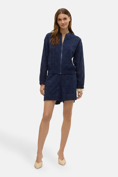 Short bleu de VERO MODA avec motif ajouré, porté avec une veste assortie et des mules couleur chair.